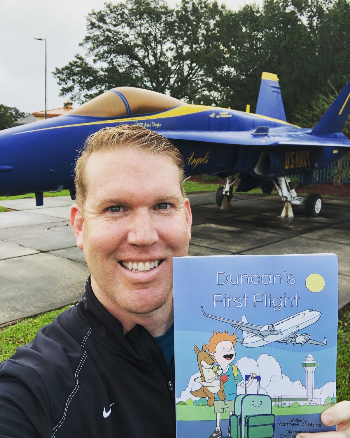 Local author Matthew Dobbins holds up a copy of his book, “Duncan’s First Flight.”